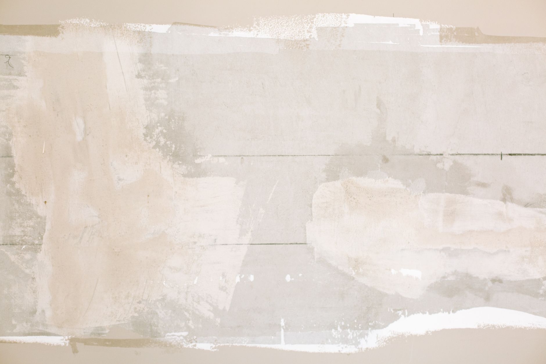 Close-up of an unfinished wall showing plaster and paint textures in a home renovation in Riverside, CA